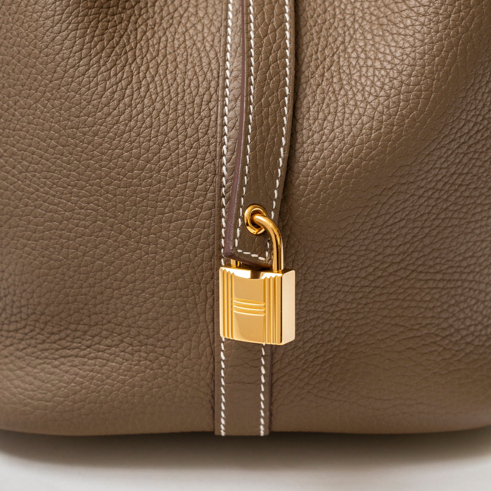 Close-up of Hermès Picotin 22 Etoupe Clemence Gold Hardware showing gold padlock on textured leather strap