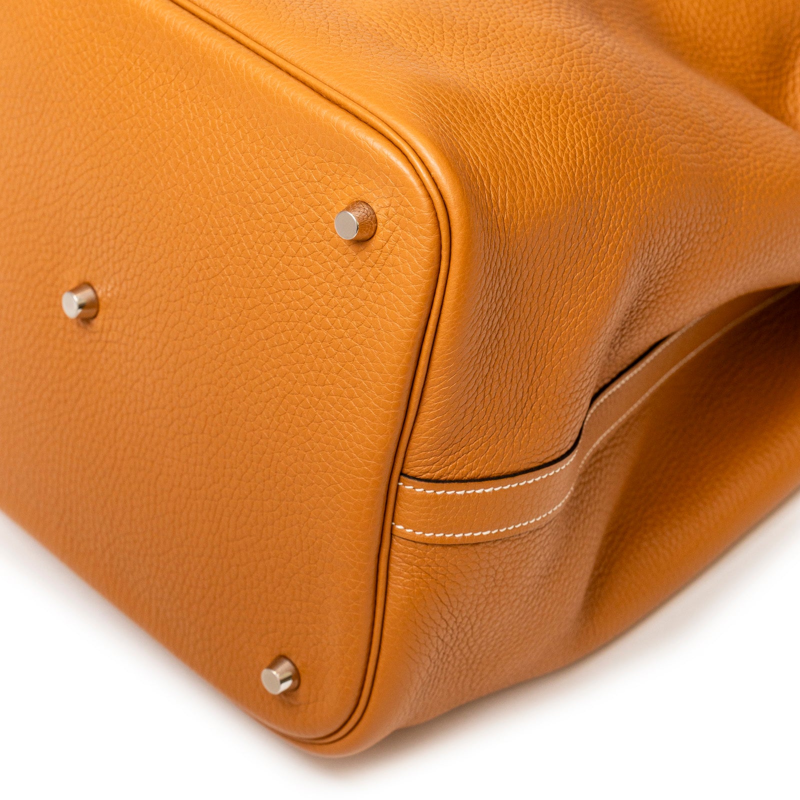 Close-up of the bottom corner showing detailed grain texture and palladium hardware of Hermès Picotin 26 Toffee Bordeaux Clemence Palladium Hardware bag.