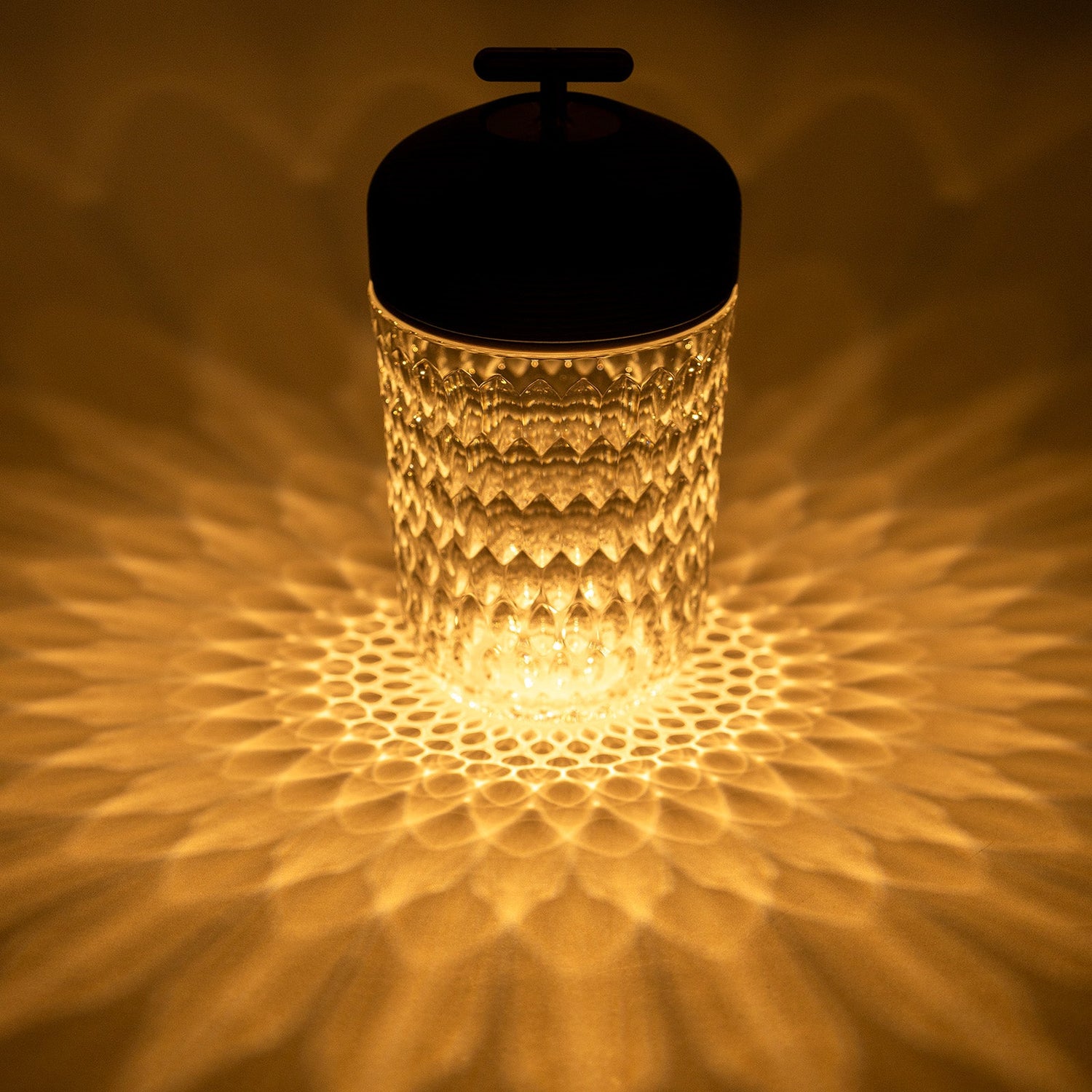 Top-down view of Hermès Saint Louis Folia Baladeuse Light Clair Clear/ Dark Wood casting intricate light patterns on surface