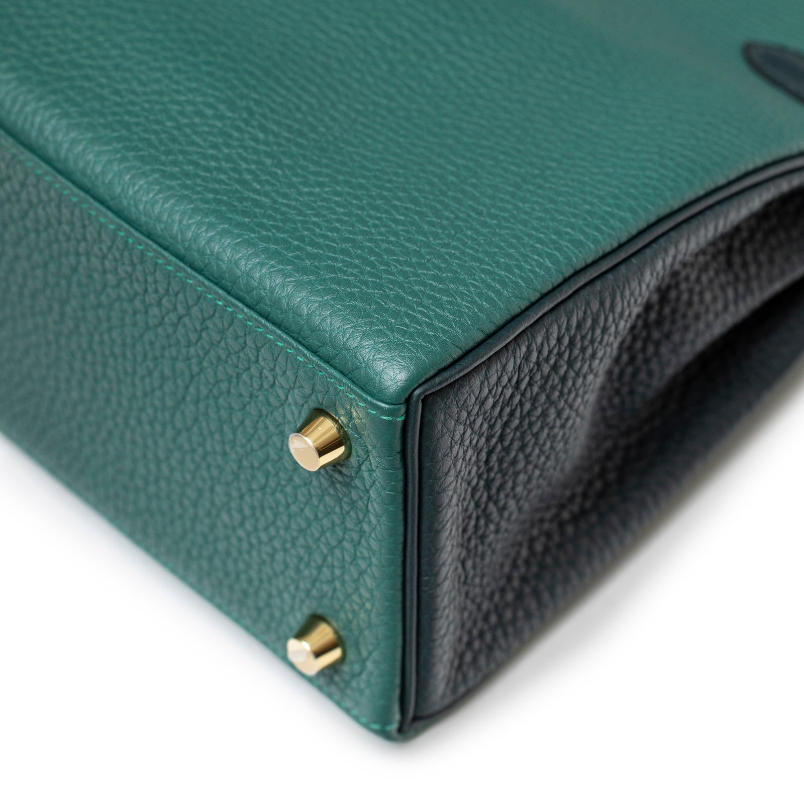 Close-up of bottom corner showing gold hardware feet and dual-tone leather on Hermès Special Order HSS Horseshoe Kelly 25 Malachite Vert Togo Gold Hardware