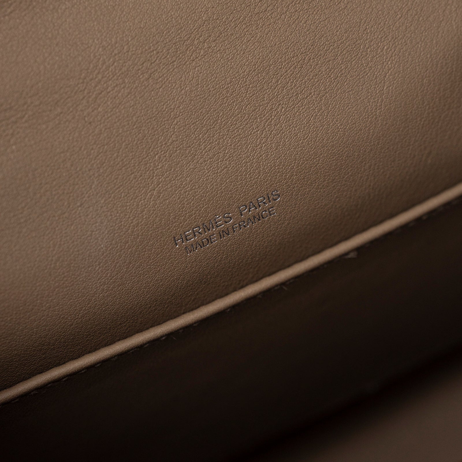 Close-up detail of Hermès Teddy Mini Kelly II Gris Caillou Etoupe Grizzly Swift Palladium Hardware interior branding stamp