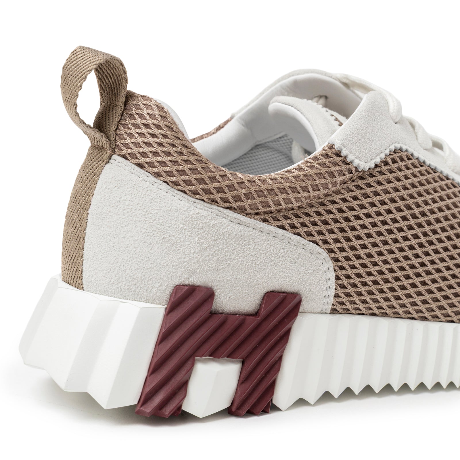 Close-up of Hermès Women's Bouncing Sneaker Beige Argile showing textured mesh upper and maroon H heel detail