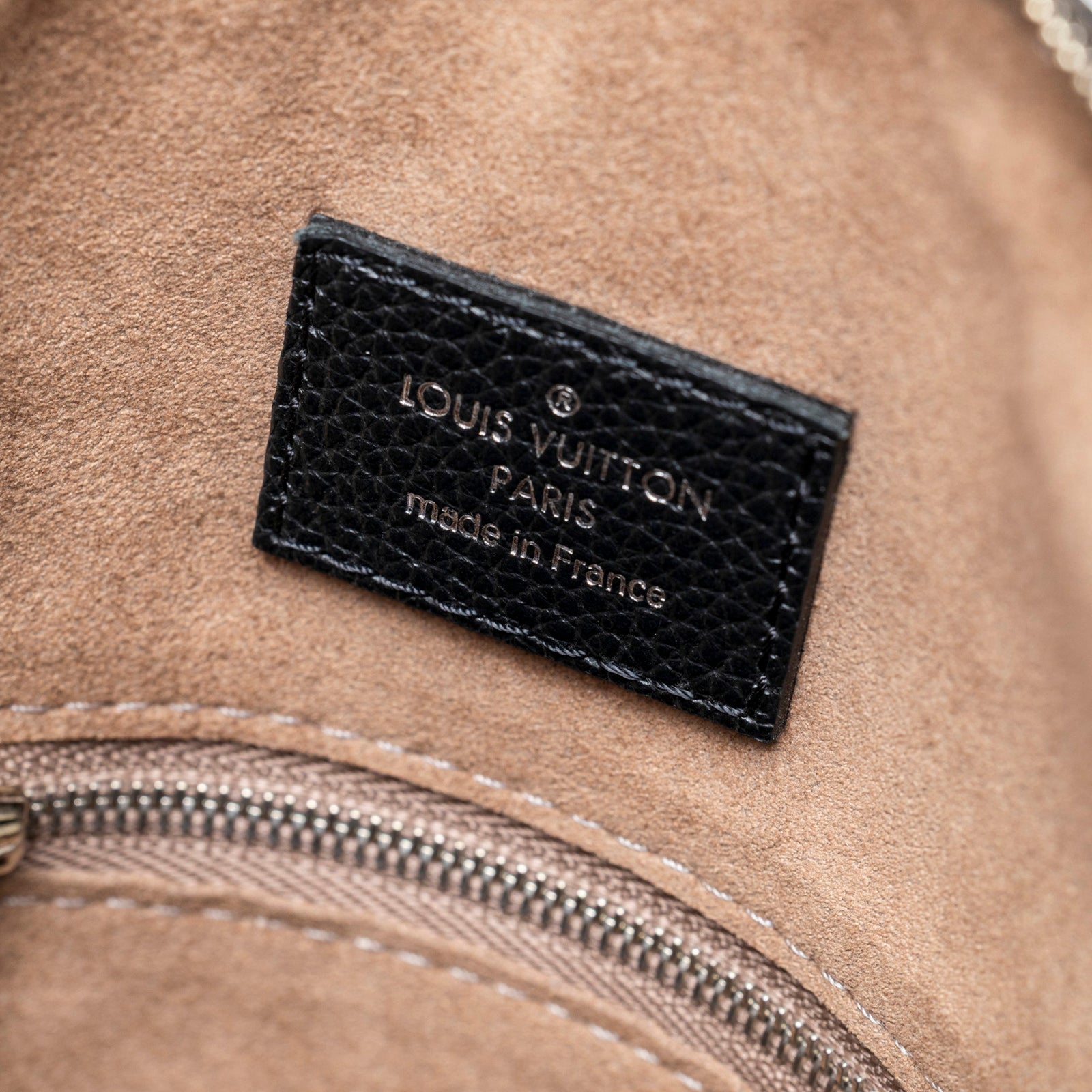 Close-up of interior label and zipper detail inside Louis Vuitton Babylon Chain BB Shoulder Bag Mahina Noir