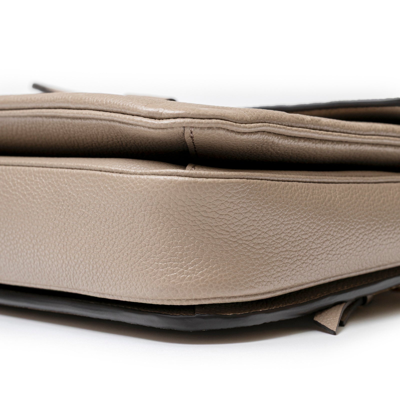 Close-up side view of Louis Vuitton Pochette Métis Monogram Empreinte Turtledove Gold Hardware leather texture and stitching details
