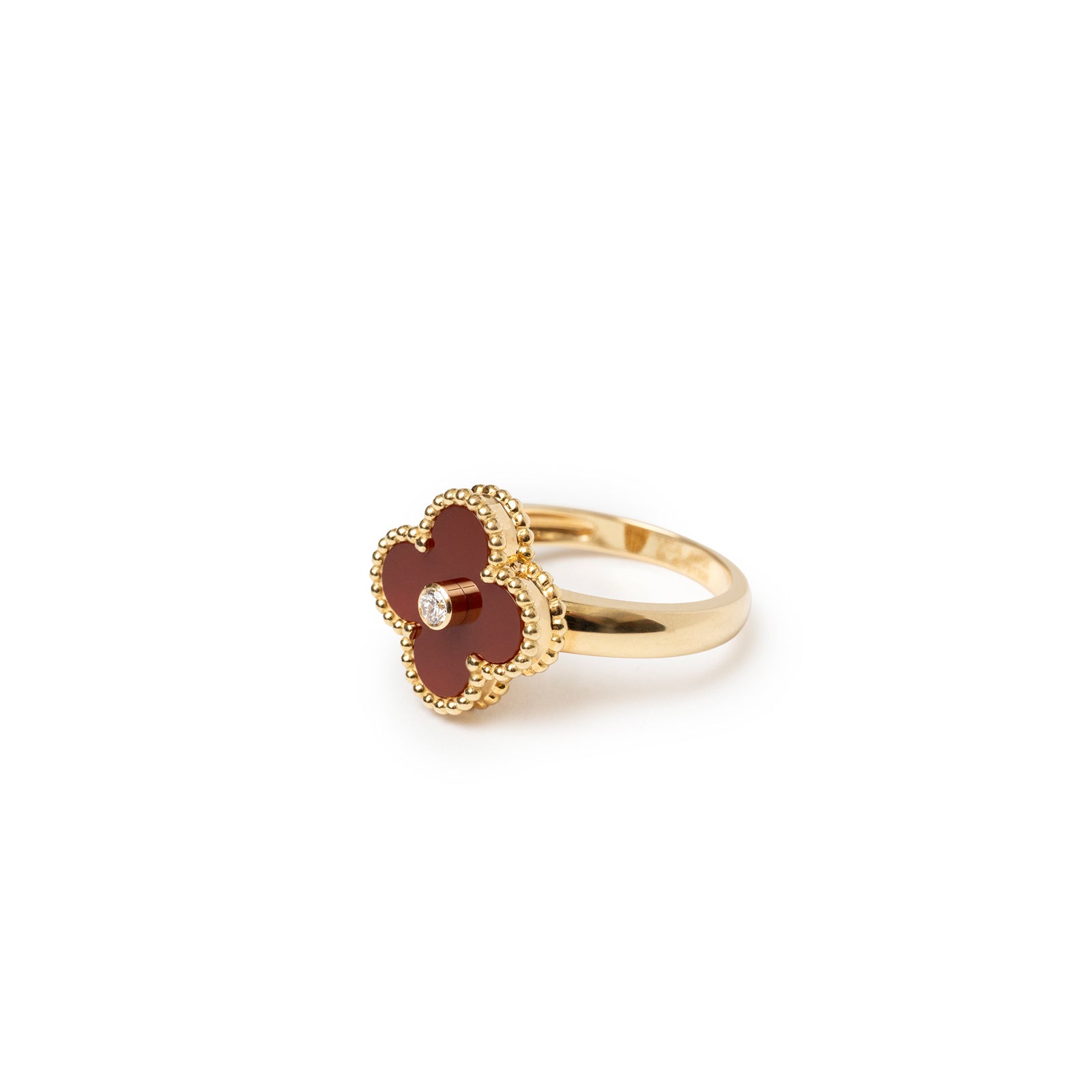 Angled view of Van Cleef & Arpels Vintage Alhambra Carnelian Diamond Ring with gold beaded edges and central diamond